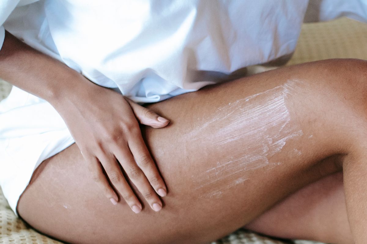 Persona aplicando crema corporal como parte de su rutina diaria
